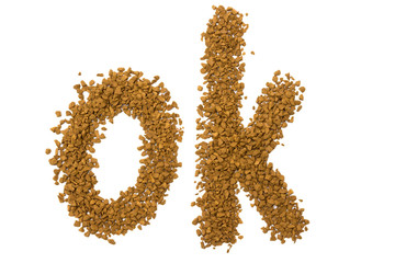 Dry instant coffee granules in the shape of a ok sign - brown texture