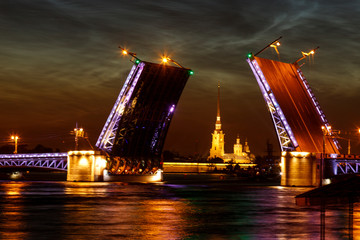 Fototapeta na wymiar Defocused city landscape of raised Palace bridge above river Neva. Feather clouds in the sky. White night in Saint-Petersburg, Russia.