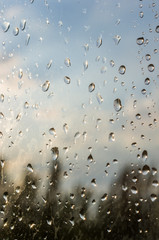 Fototapeta premium raindrops on window glass on background of cloudy sky