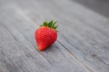 Bright, juicy strawberry on a wooden surface. View from above