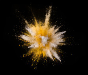 Explosion of yellow powder on black background