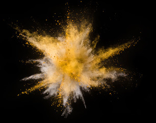 Explosion of yellow powder on black background