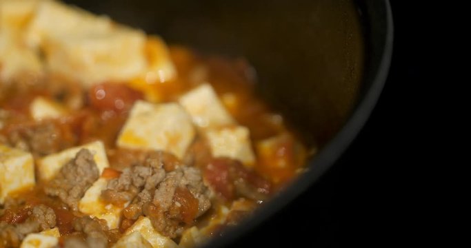 Asian chef cooking Chinese style Sichuan mapo tofu food in a hot pan