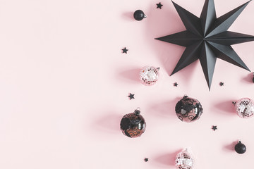 Christmas composition. Christmas pink and black decorations on pastel pink background. Flat lay, top view, copy space