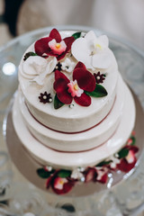 Obraz na płótnie Canvas wedding cake with decorated with red and white orchid petals