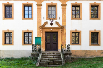 Fortress wall of a historical building in Bouzov, Czech Republick, close-up look at the decorated color wooden door surrounded by wall and window. Hájovna Jägerhaus.