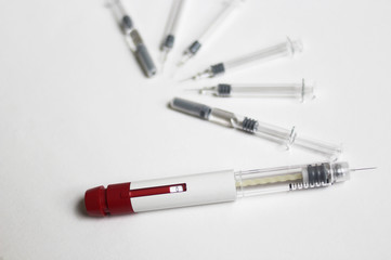 In Vitro Fertilization injection pen. IVF treatment drugs, syringes, needles and pills. Stims and pio shots. Medication for infertility treatment on white background.  