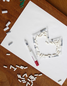 Assisted reproductive technology injection pen. IVF drugs, syringes, needles and pills. Stims and pio shots. Medication for infertility treatment on white background.  heart made of pills and syringes