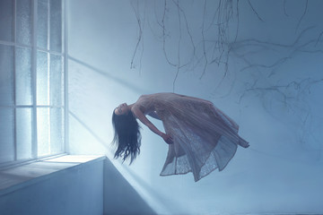 Dreaming woman levitating in empty room