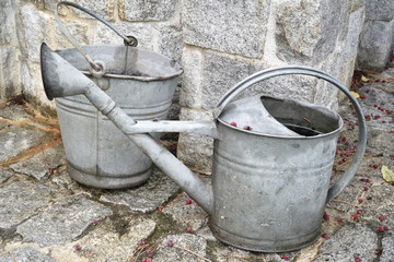 Old watering can and bucket in the garden