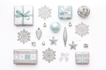 Beautiful christmas gifts and silver snowflakes and ornaments isolated on white background. Pastel...