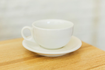 white empty cup on wooden table in a restaurant