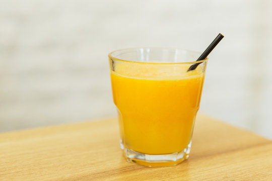 Orange juice in a glass on wooden table in a restaurant