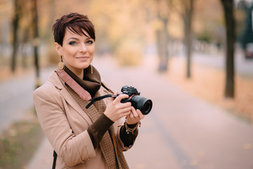 portrait female photographer on background of autumn city