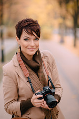 portrait female photographer on background of autumn city