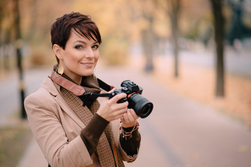 portrait female photographer on background of autumn city