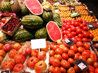 fruits and vegetables on a farmers market stall with empty white sign