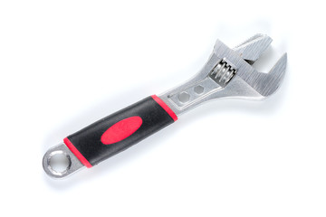 Adjustable wrench with black and red insulating handle. Spanner isolated on white background.