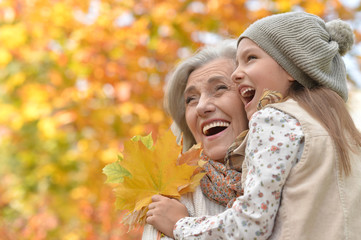 Portrait of grandmother and granddaughter in autumn park
