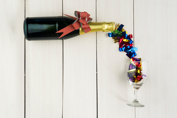 Champagne bottle with glass filled with streamers