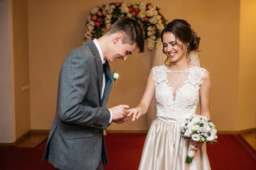 The bride and groom are exchanging wedding rings. Wedding ceremony in the registry office.