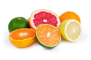 Whole and halves of various citrus on a white background