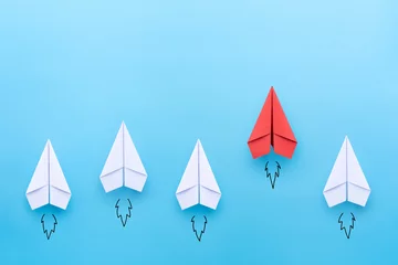Fotobehang Red paper plane leading among a white planes on blue background. Business competition and Leadership concept © Worawut
