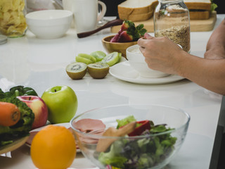 Young man eating cereal breakfast and fruits to healthy in morning before work.