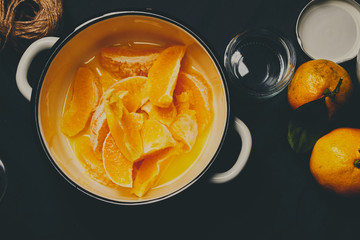Peeled oranges in white pot ready to be cooked for jam