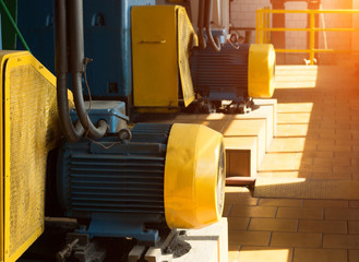 Two large electric motors in the production workshop, against the background of sunlight, electric...