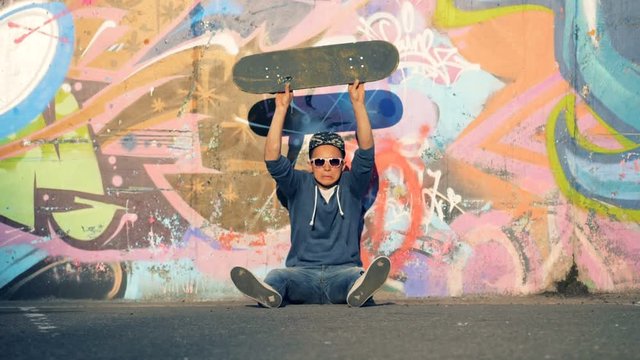 A teenager throws his board away, slow motion.