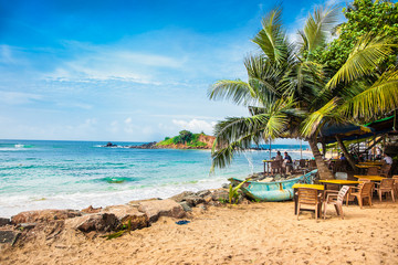 Obraz premium Tourists on the sand while beach of Mirissa. Sri Lanka.