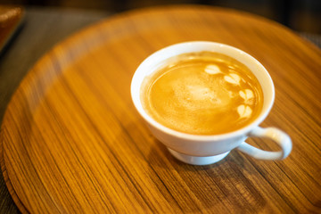 Hot coffee latte on a wooden tray (soft focus)