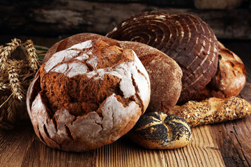 Different kinds of bread and bread rolls on board from above. Kitchen or bakery
