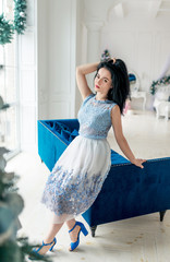 young charming brunette in a refined dress in a stylish New Year's interior