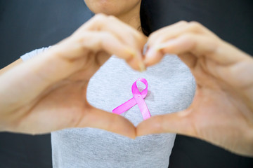 Unknown woman showing pink ribbon