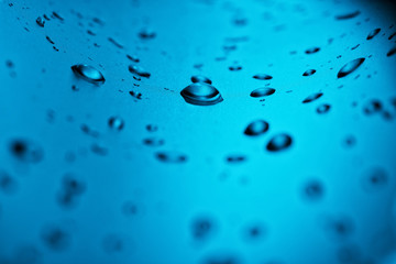 Drops of clean water on the glass. Blue background