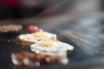 Cutlets from minced meat roasted on the grill. chicken eggs and tomatoes on the grill. breakfast in restaurant