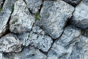 series of gray large stones uneven weathered monochrome pattern base close-up base geology