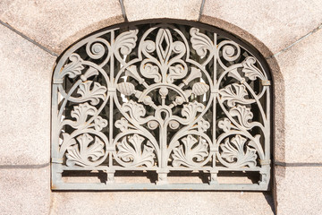 Beautiful decorative lattice in the window opening of the ancient wall of the Orthodox Church.