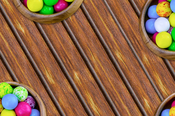 set of sweets round yellow blue pink in bowls a lot bonbon covered with icing on an inclined wooden table