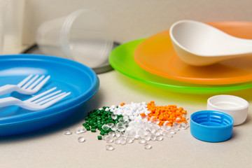 Plastic disposable tableware and Plastic Raw material. Colored granules of polyethylene, polypropylene. BPA FREE concept - obrazy, fototapety, plakaty