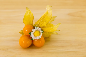 Cape gooseberry, physalis orange juicy fruit open fruit with thin fonaric walls on a wooden background