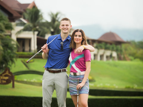 Couple golf concept : Young Man teaching his girl friend playing golf