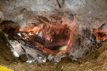 Blue lake in an underground cave. The concept of natural dark areas.