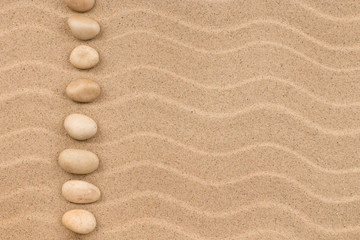 Fototapeta na wymiar Line made of white stones among sand dunes.