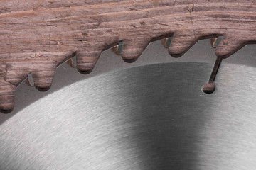 Close-up, metal circular saw blade on a wooden background