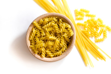 Uncooked pasta in a wooden bowl.