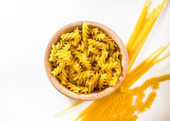 Uncooked pasta in a wooden bowl.