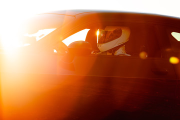 A Race Car Driver At The Wheel Waiting To Take To The Track As The Early Morning Sun Rises In The...